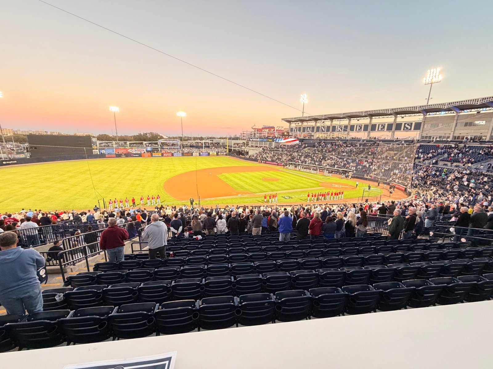 National anthem with players lined up along the baselines at sunset